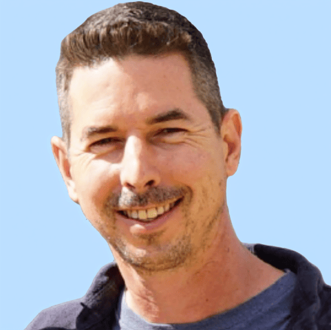 A man with a beard and mustache is smiling for the camera.